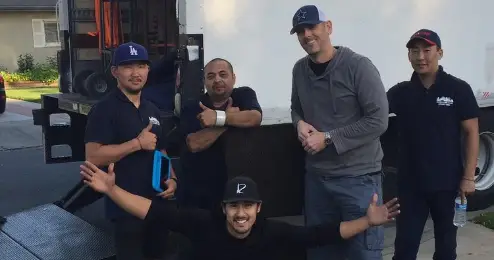Five movers in front of a truck